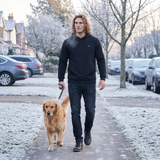 Man walking his dog on a frosty street in a black 9-zone heated hoodie