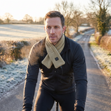 Man cycling a frosty country road wearing a khaki heated scarf