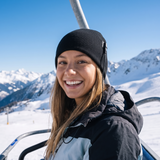 Woman on a ski chairlift wearing a black heated knit beanie